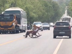 大爷躺马路中间晒太阳 车辆纷纷避让 到底啥来头？