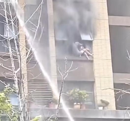 小区火灾女子带娃窗外避险跌落